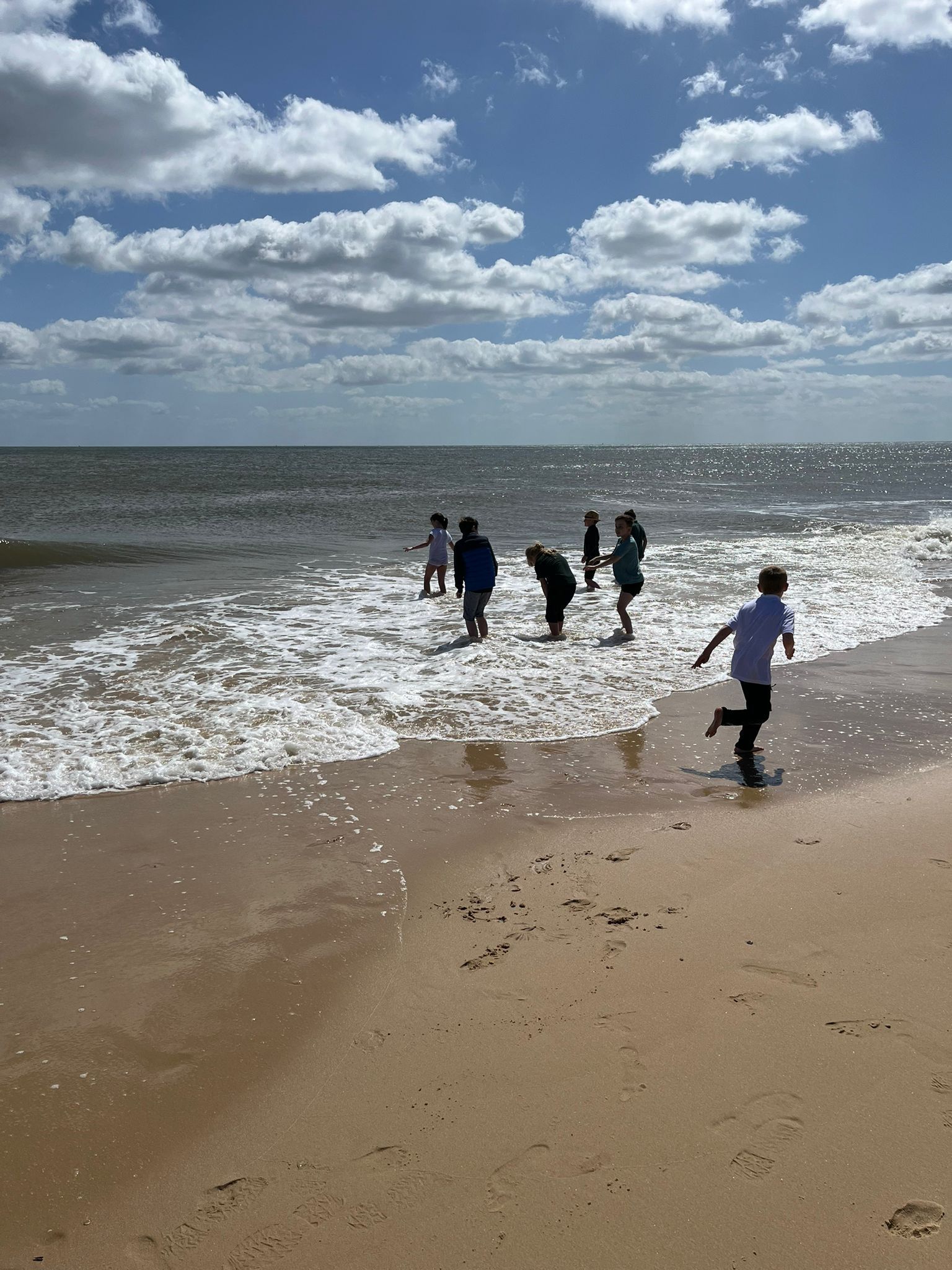 students playing in the water at the beach 