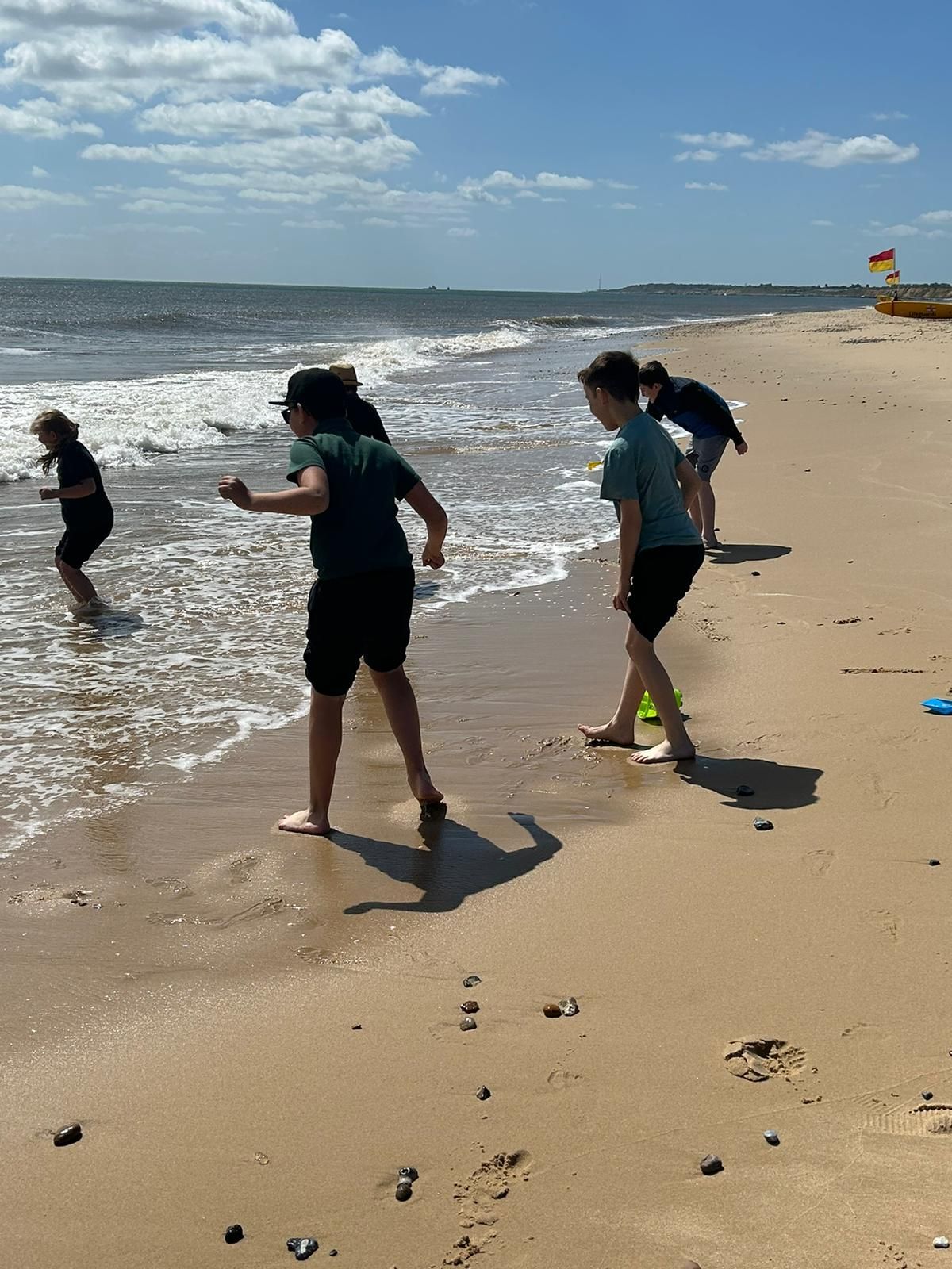 students playing in the water at the beach