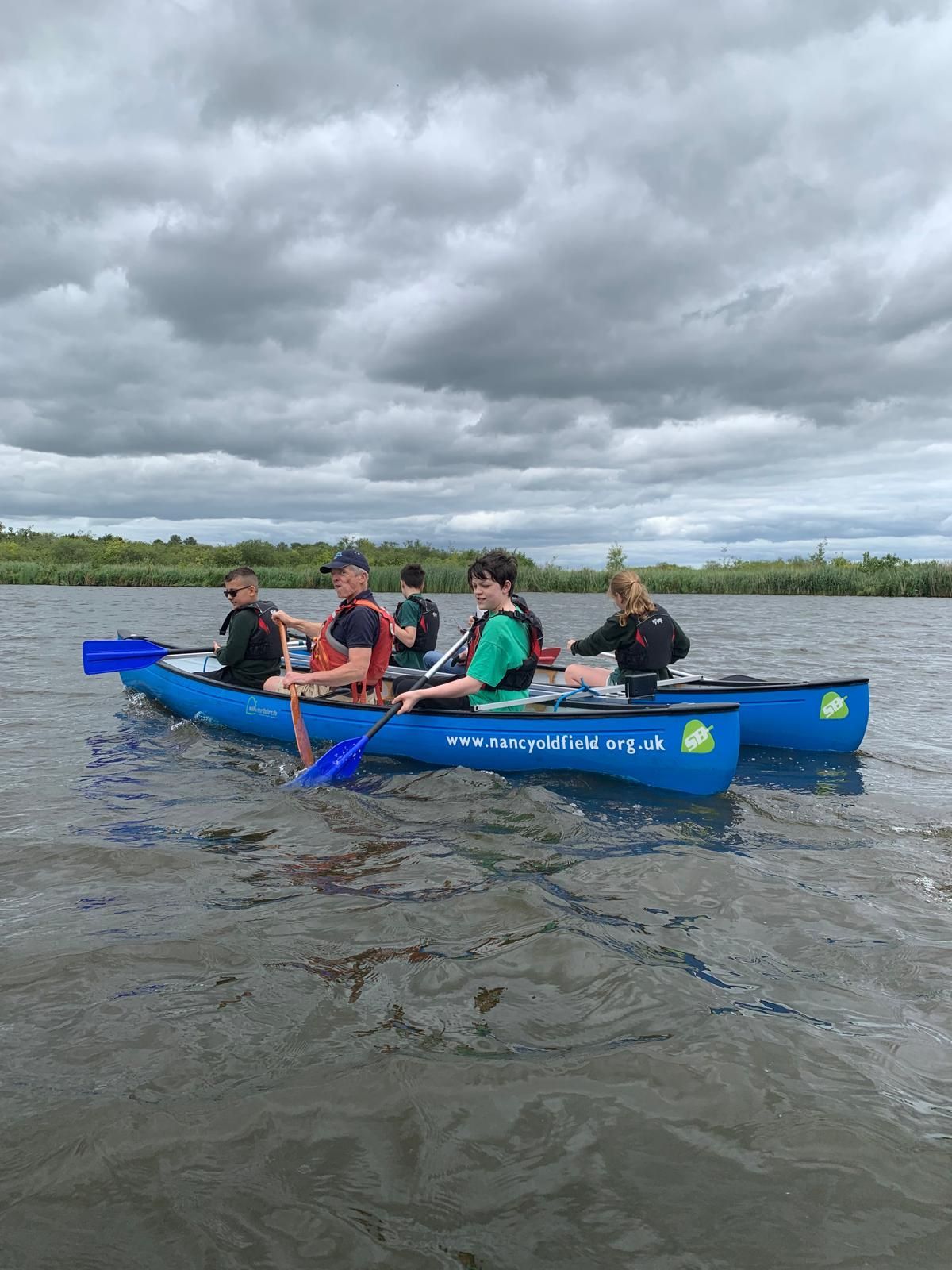 students and staff on a boat