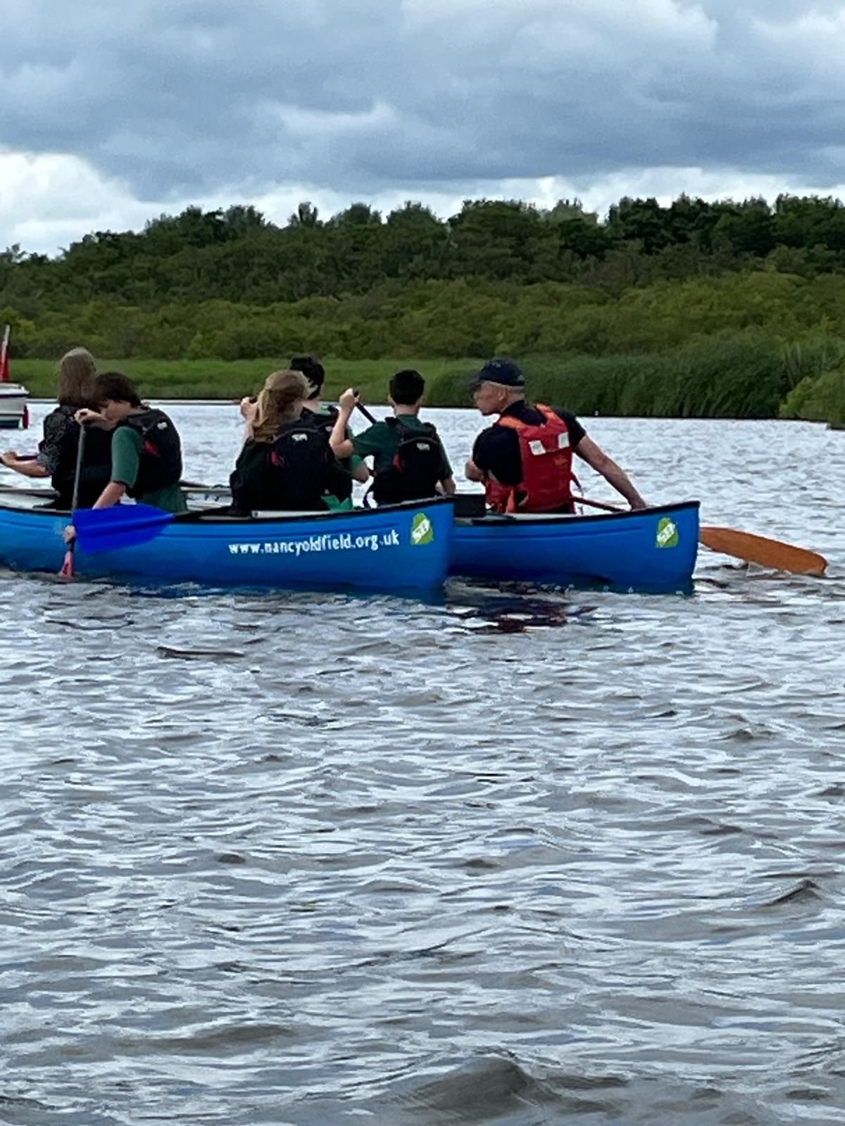 students and staff on a boat