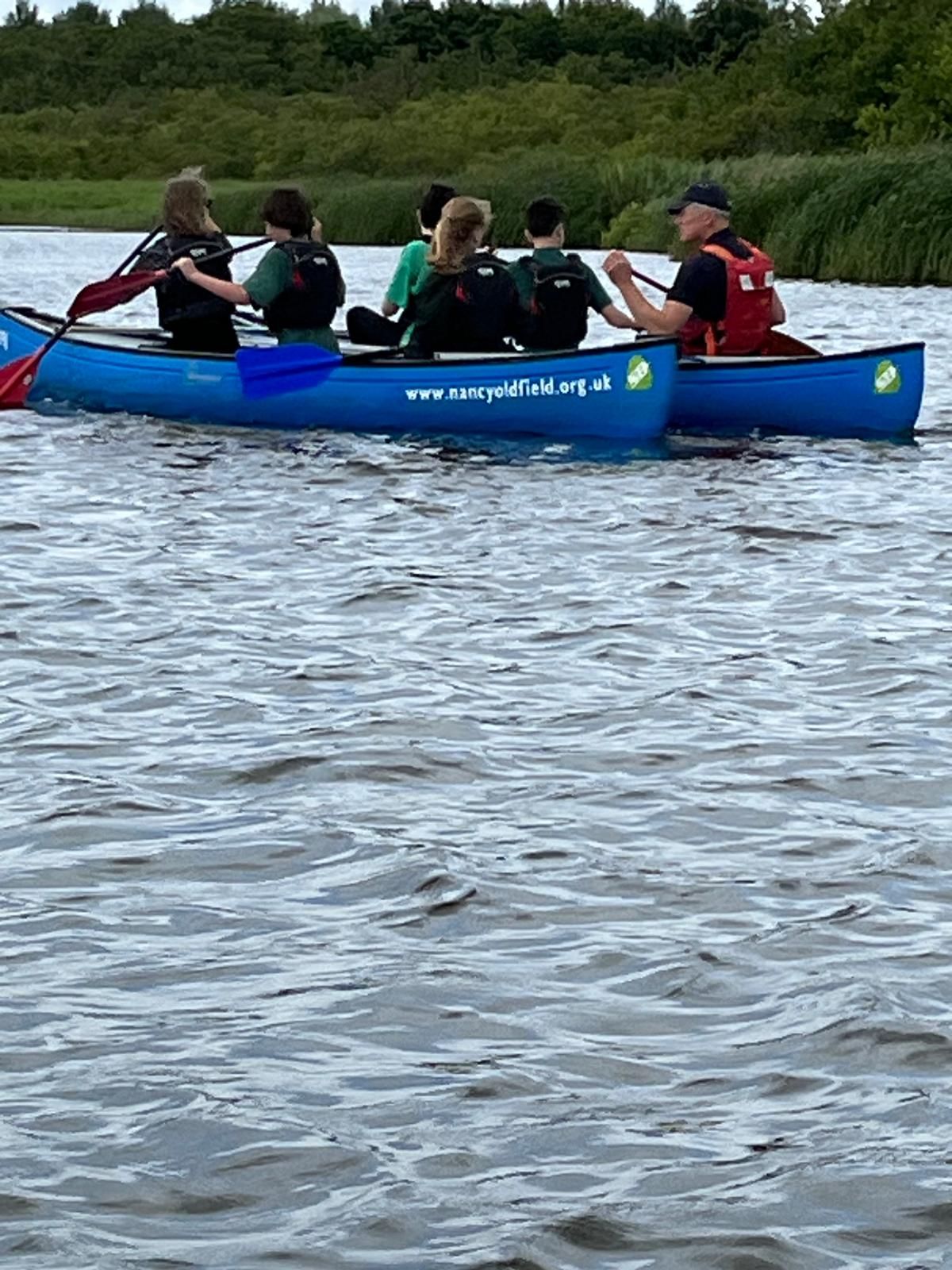 students and staff on a boat
