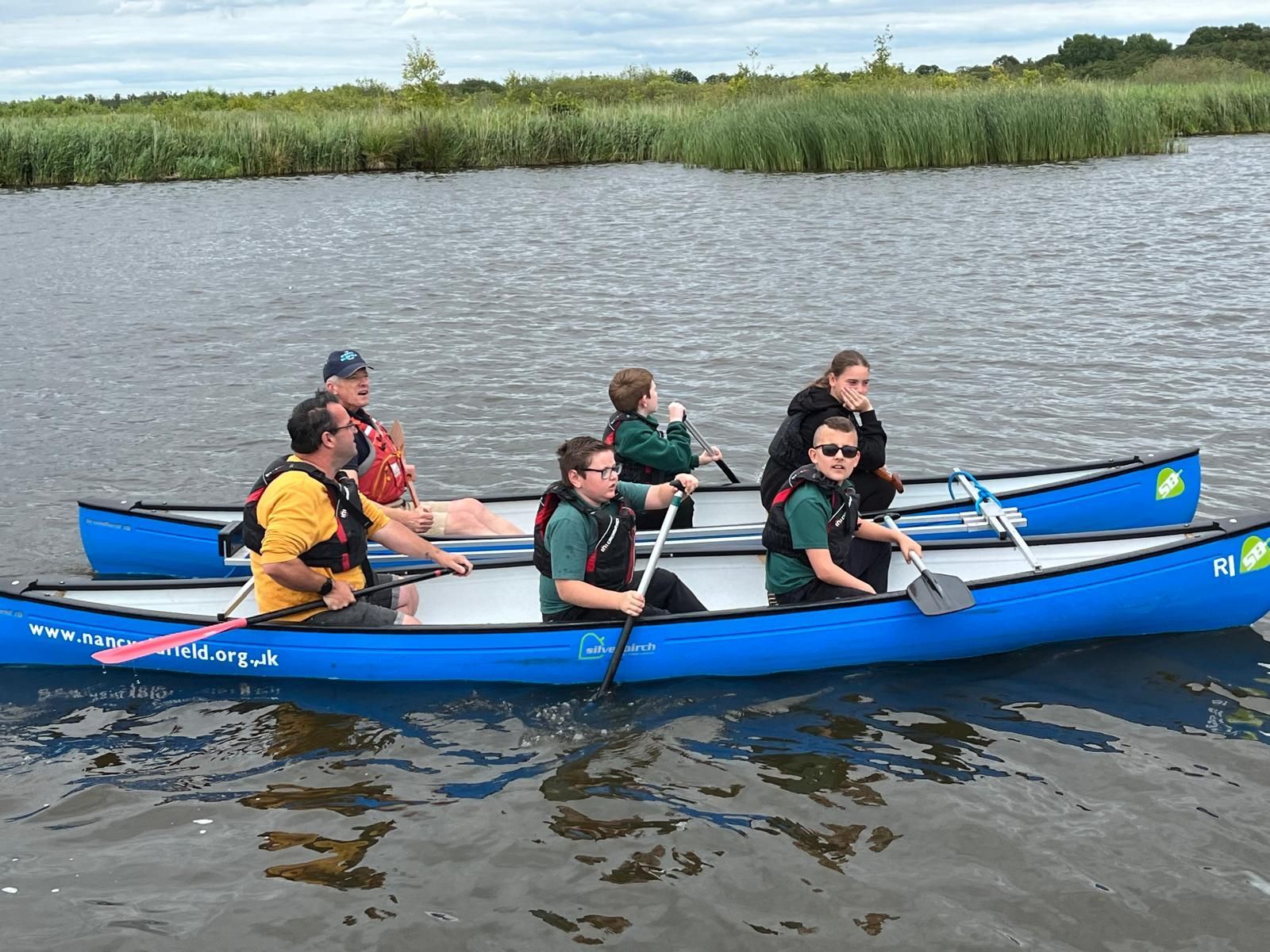 students and staff on a boat