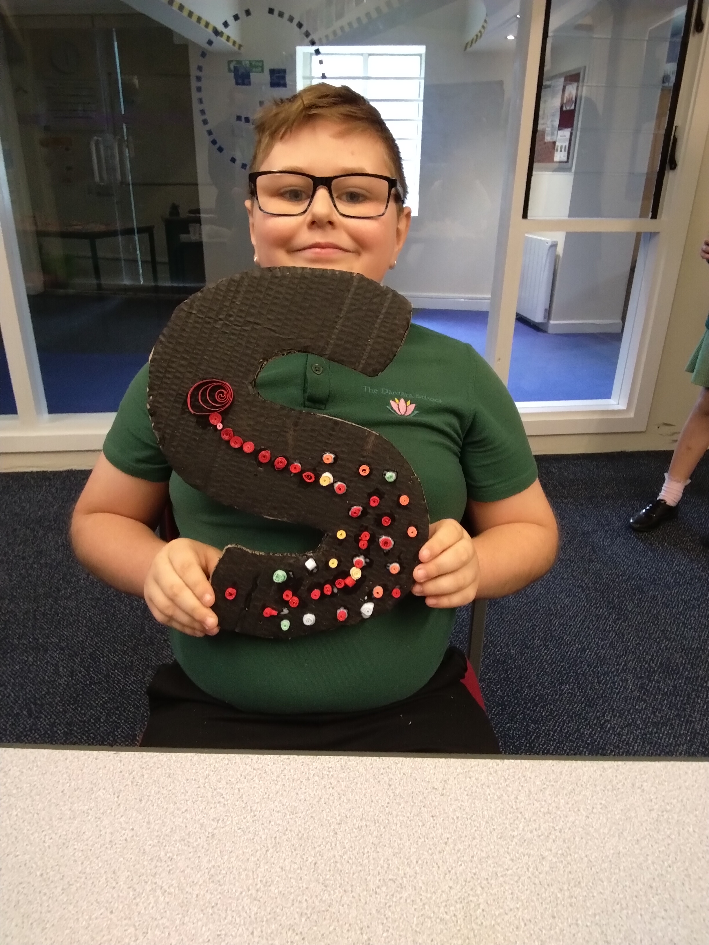 student smiling showing artwork