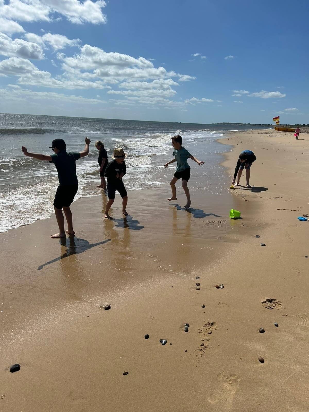 students playing in the water at the beach 